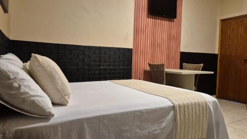 Suítes privativas, camas confortáveis, piscina, churrasqueira e playground, Roupa de Cama e tolha de banho.